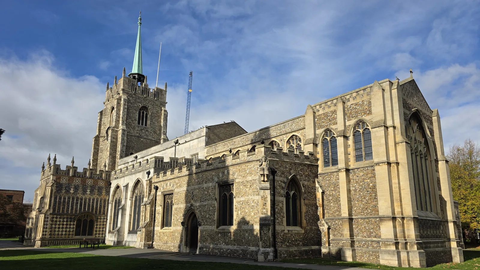 Chelmsford Cathedral seen from the churchyard in the city centre, under a blue sky.